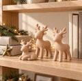 Kit 3 renas de Natal decorativas, cor Bege, em estante com livros e pisca-pisca