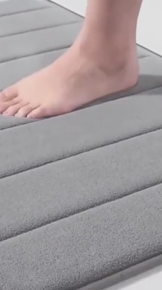 Vídeo: pés molhados no tapete cinza e a água absorvida